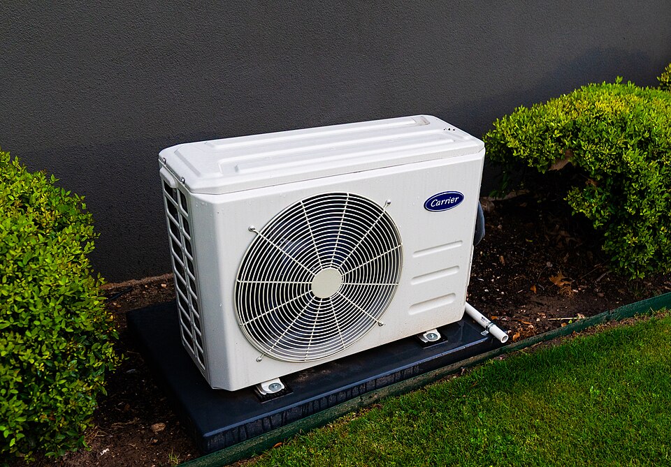 Outdoor heating and cooling unit beside a home